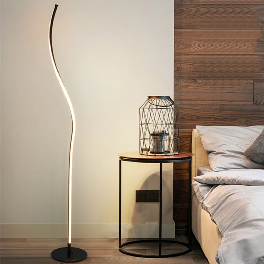Modern curved LED floor lamp in a bedroom