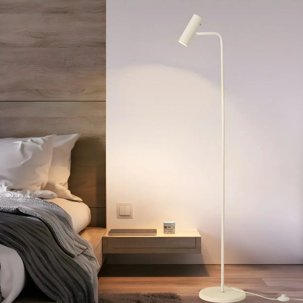 Modern adjustable LED floor lamp beside a bed