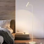Modern adjustable LED floor lamp beside a bed
