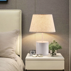Modern fabric shade table lamp beside a bed
