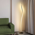 Modern curved LED floor lamp beside a sofa