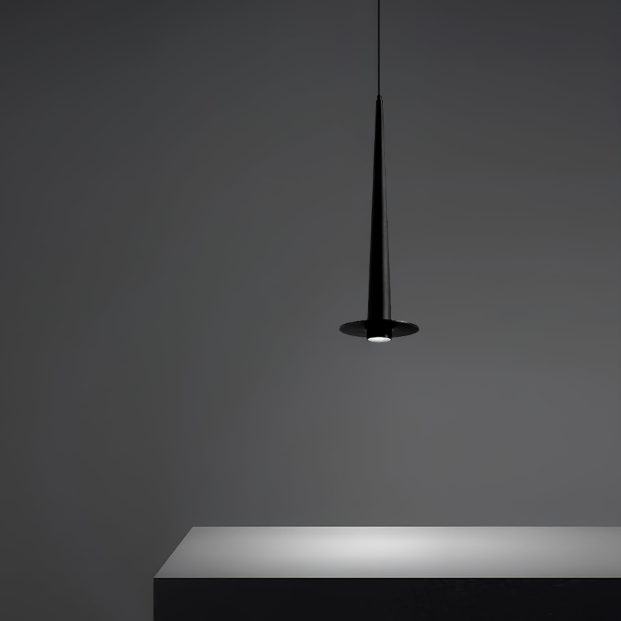 Modern minimalist black aluminum stick LED pendant ceiling light above a kitchen island