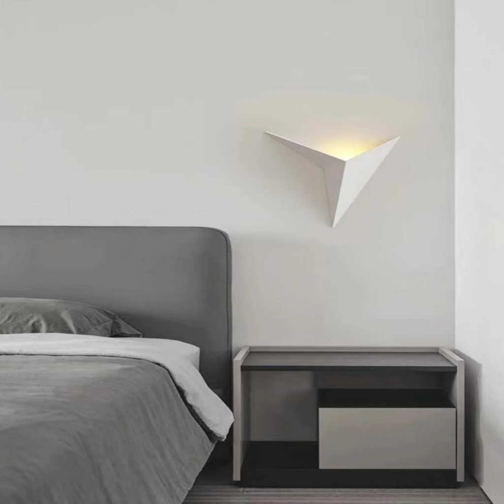Modern triangle LED wall sconce in a bedroom
