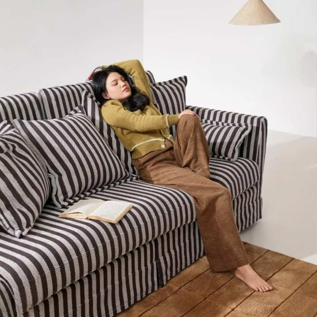 Woman relaxing on an elegant striped sofa