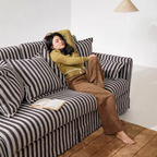 Woman relaxing on an elegant striped sofa