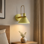 Yellow industrial conical wall sconce in a bedroom
